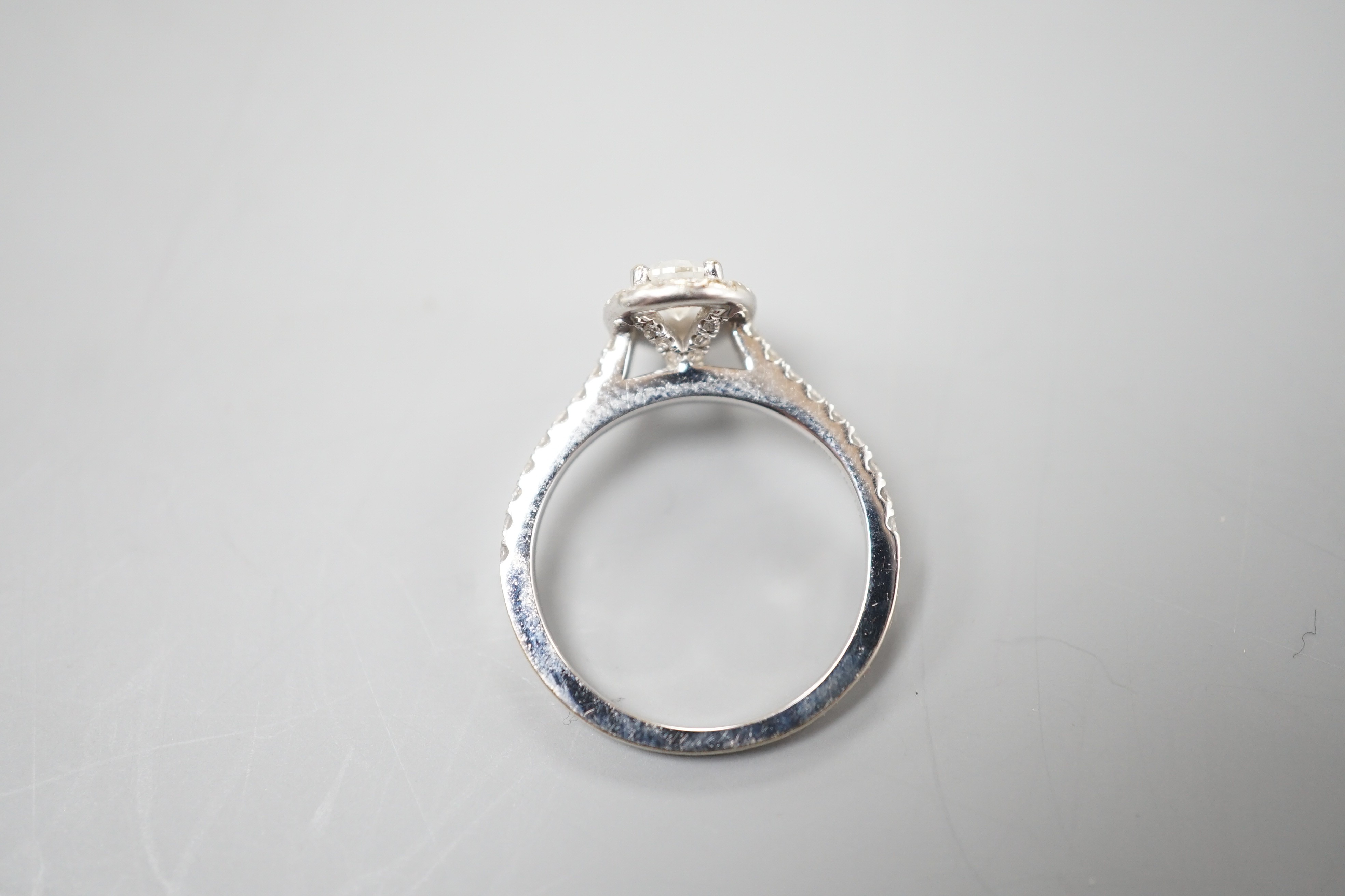 A modern '77 Diamonds' 18ct white gold and singe stone pear cut diamond set ring bordered with brilliants, with GIA report date 29/12/2016 stating the single stone to weigh 0.50ct with a colour and clarity of I and VS1,